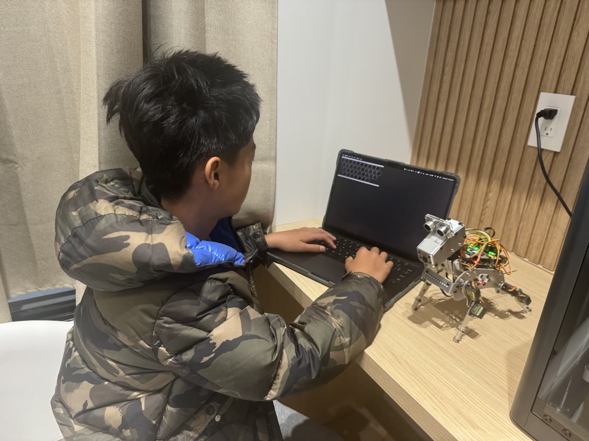 Edwin working on Smart Dog controls beside a laptop